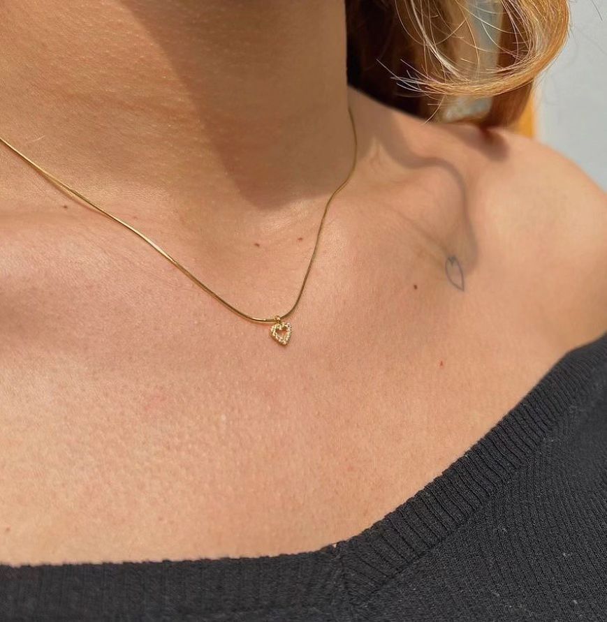 Tiny Diamond Heart Necklace with a sparkling heart pendant on a woman