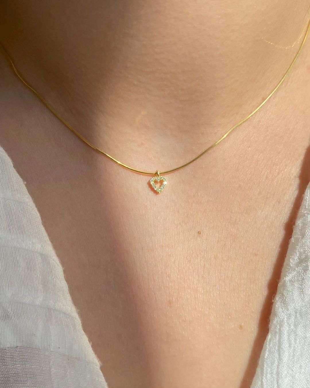 Woman wearing a delicate Tiny Diamond Heart Necklace with elegant heart pendant