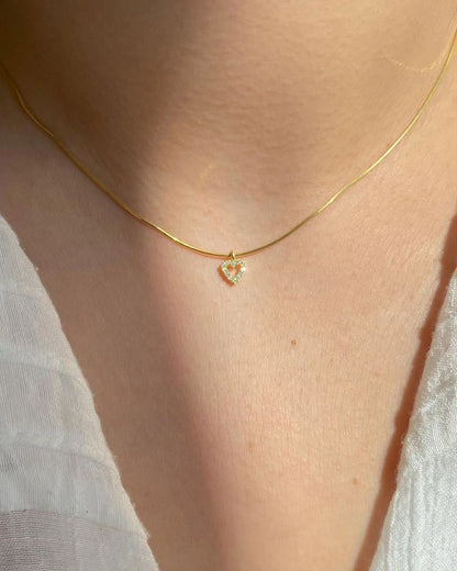 Woman wearing a delicate Tiny Diamond Heart Necklace with elegant heart pendant